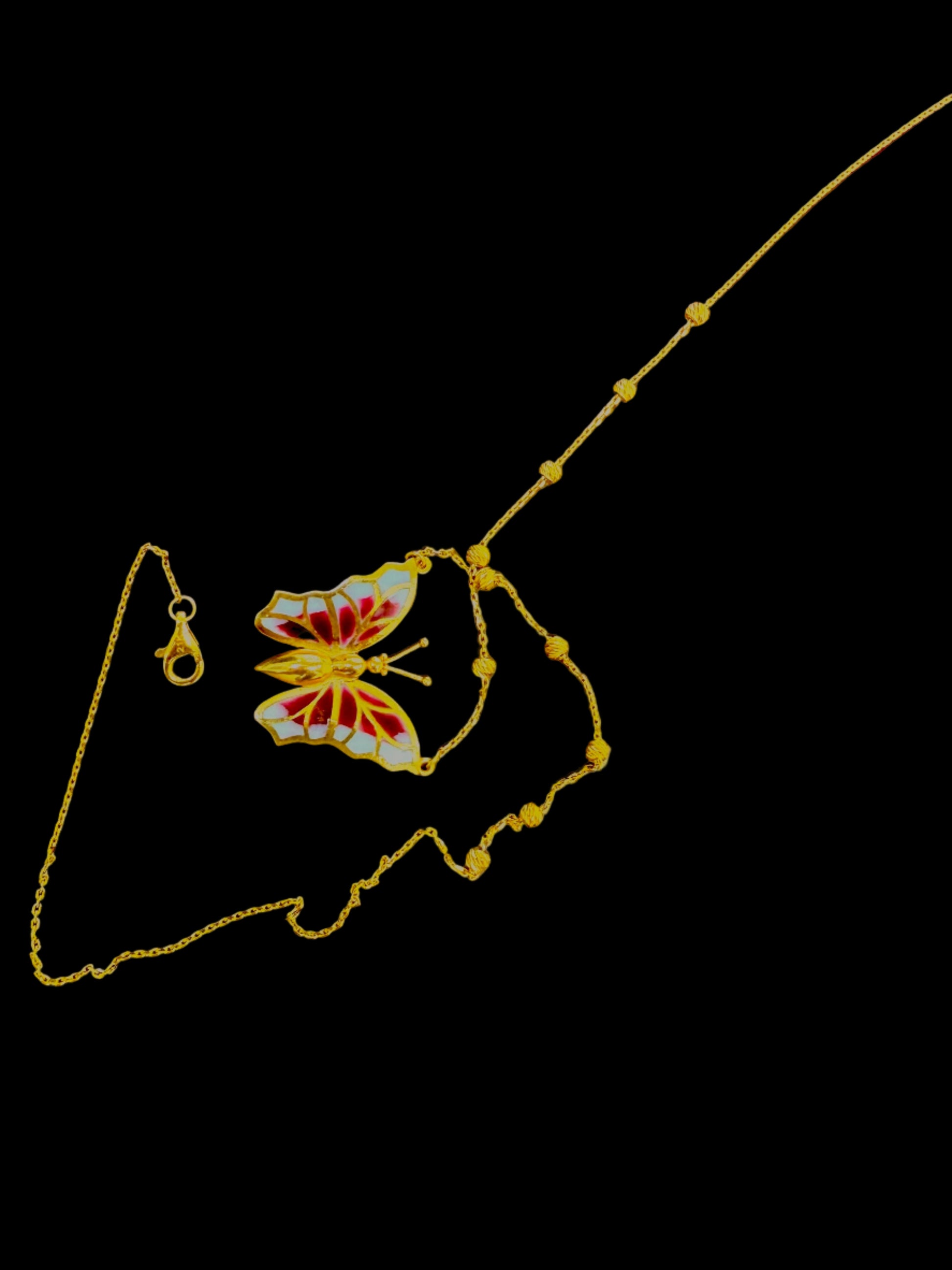 Butterfly-shaped pendant on a chain on a wooden surface