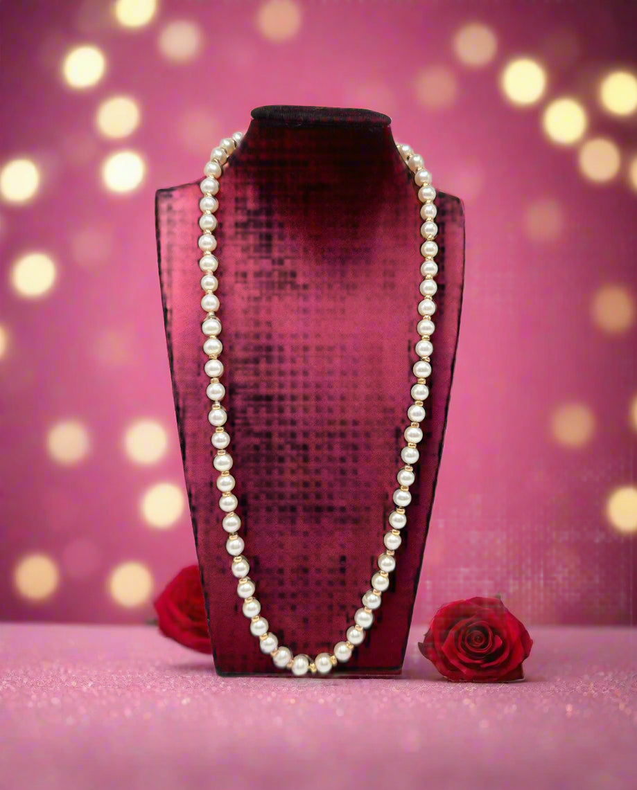 Pearl necklace on a black velvet stand against a white background