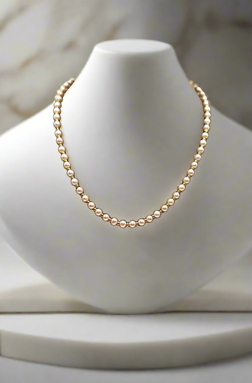Pearl necklace on a black mannequin bust against a white background