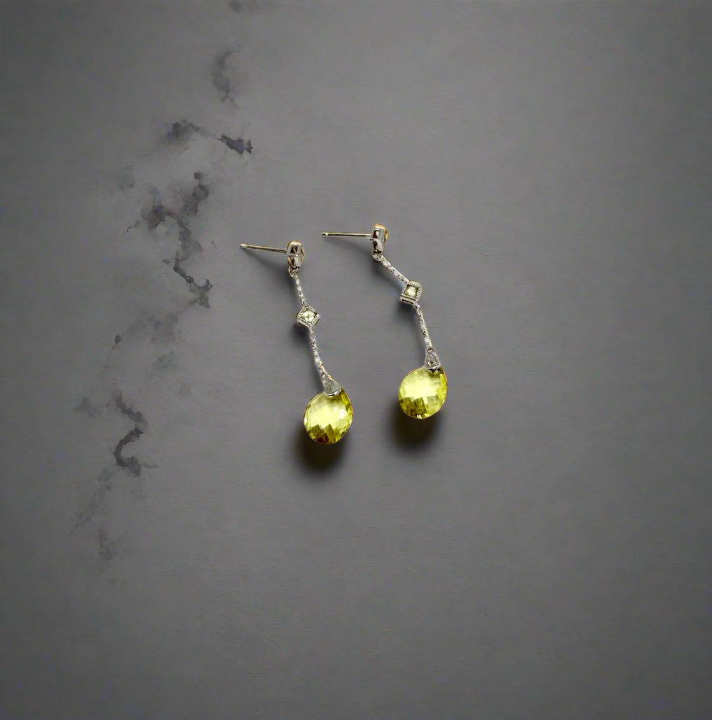 Pair of earrings with yellow gemstones on a white background