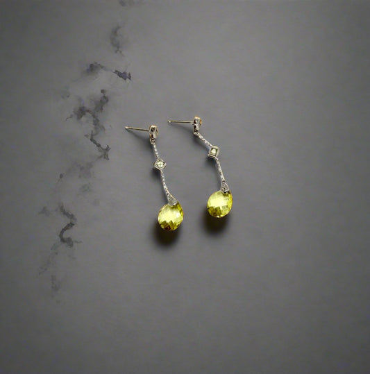 Pair of earrings with yellow gemstones on a white background